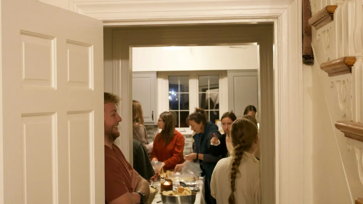 Amigos reunidos alrededor de la mesa en la fiesta de una casa