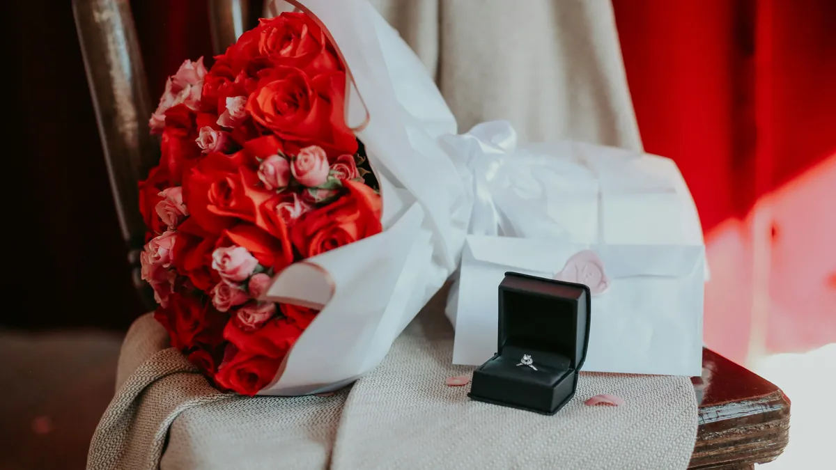 Un ramo de rosas rojas y un anillo en su estuche