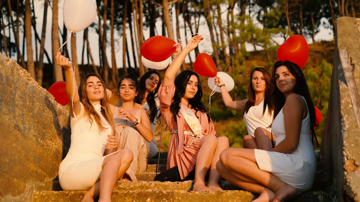 A group of friends celebrate with heart balloons at a bachelorette party