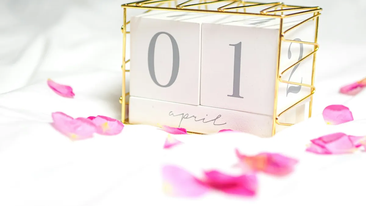 Un calendario de cubos marca una fecha entre pétalos de rosa