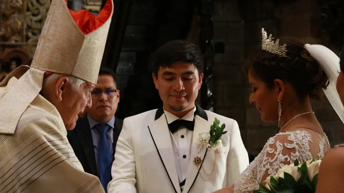 The bishop blesses the couple at the altar during a church wedding in Peru