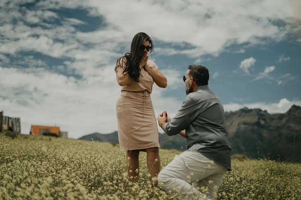 He kneels with the ring in a flower meadow in Maras, Cusco, as she raises her hands to her face