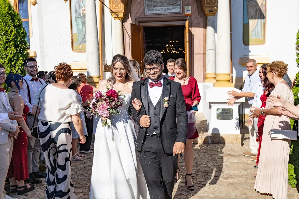 Los novios saliendo de la ceremonia entre sus invitados, que los reciben aplaudiendo