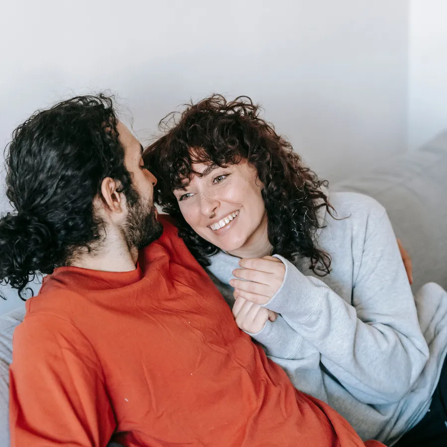 Una pareja abrazada en el sofá de su casa nueva