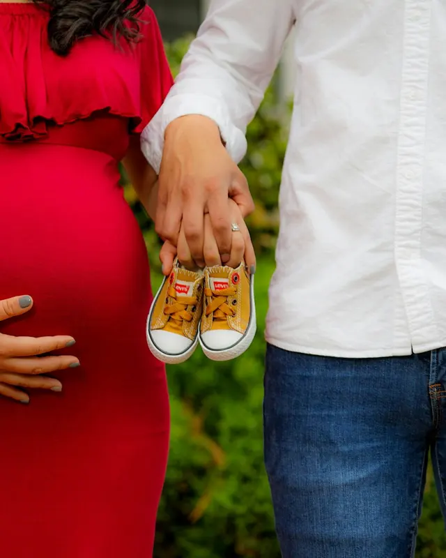 Expecting parents holding baby shoes